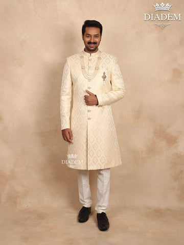 Cream Raw Silk Sherwani Suit Adorned with Floral Embroidery, Paired with Brooch and Bead Mala - Diadem