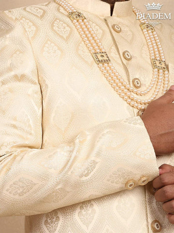 Cream Raw Silk Sherwani Suit Adorned with Floral Embroidery, Paired with Brooch and Bead Mala - Diadem